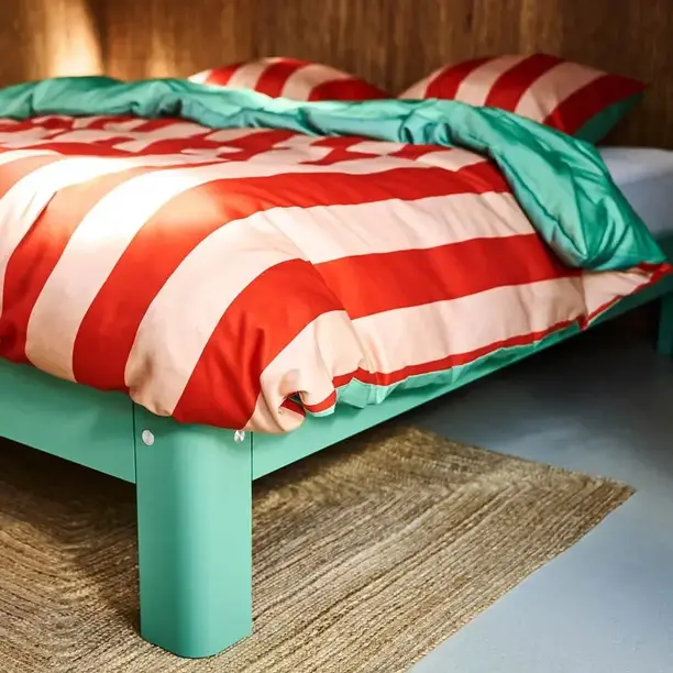 Rood-wit gestreept Auping-dekbedovertrek met een mintgroene binnenkant op een mintgroen bed