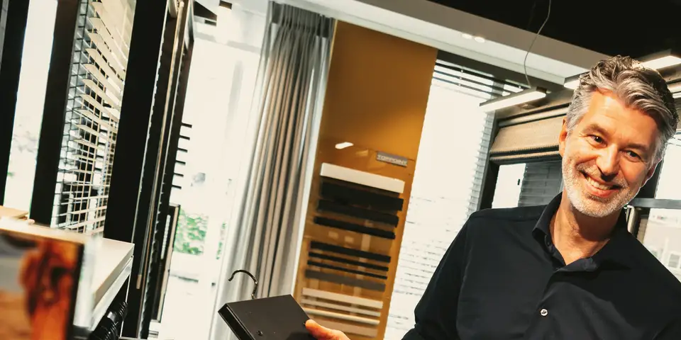 Ronald Wielinga met een stalenboek voor raambekleding in onze showroom