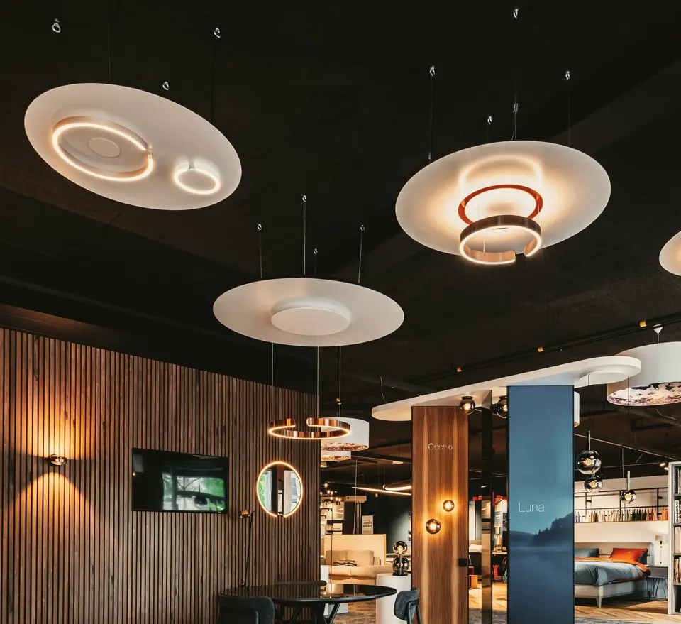 Lichtschijven met koperen ringen boven de adviestafel in onze showroom