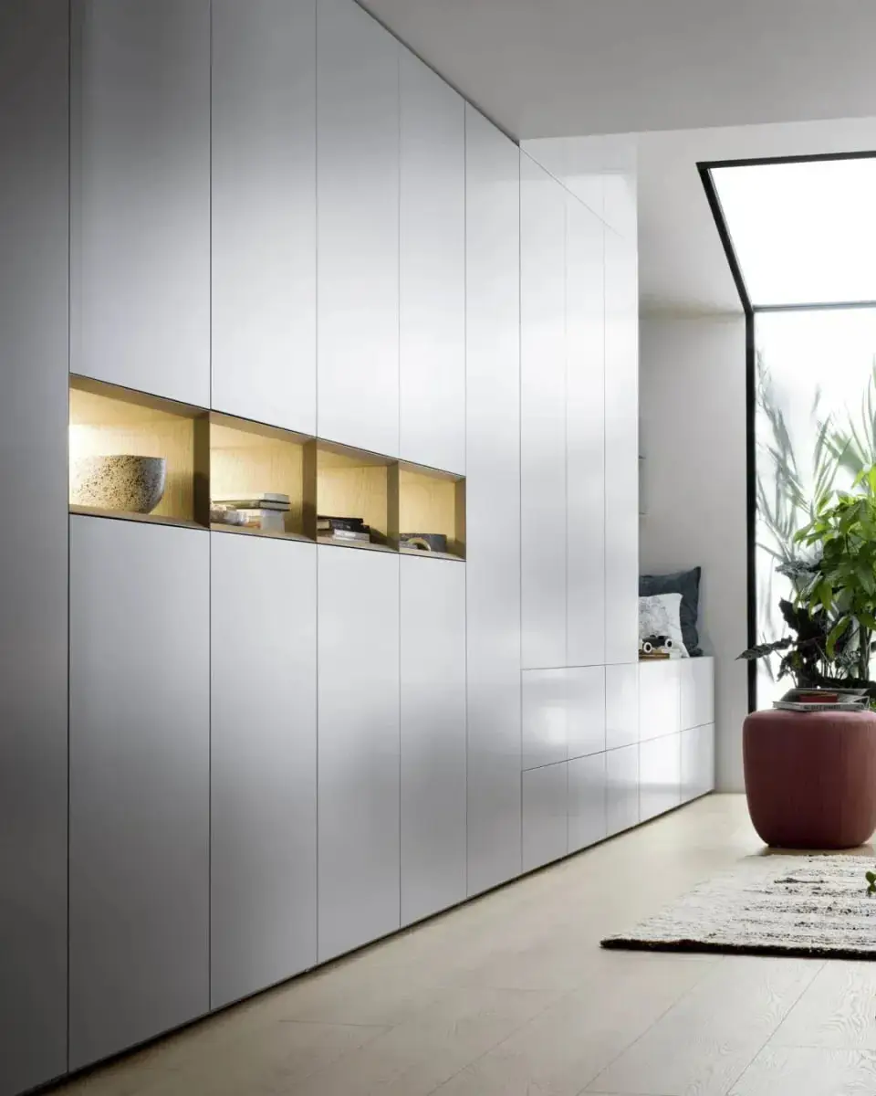 Greeploze kastenwand van vloer tot plafond met verlichte eiken nissen