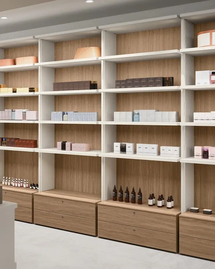 Wandkast met open vakken en houten laden achter een lichte balie in een winkel