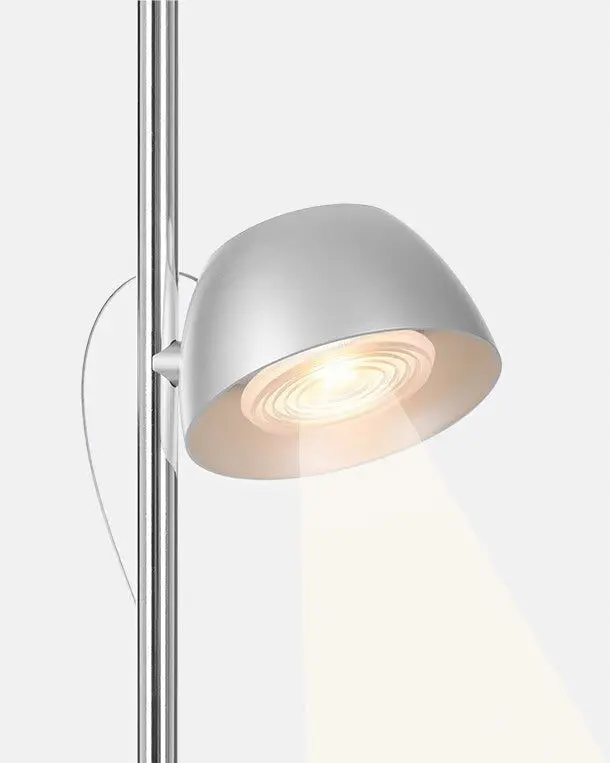 Detail van een zilveren lampkop die een lichtbundel naar beneden werpt