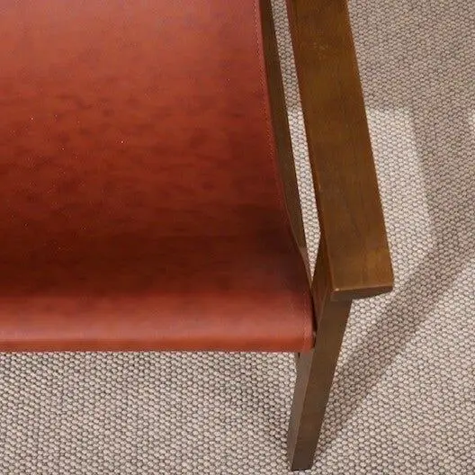 Leren stoel met een houten armleuning op grijs wollen tapijt