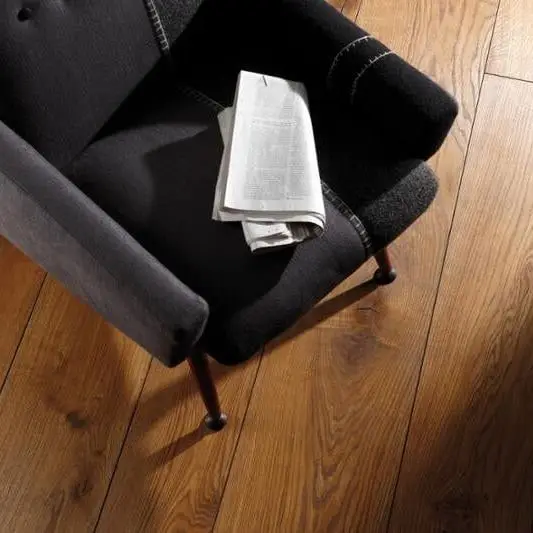 Donkere fauteuil op brede, warme eiken planken, van boven gezien