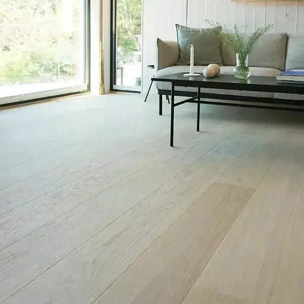 Lichte woonkamer met een grote pui en brede, bijna witte eiken planken