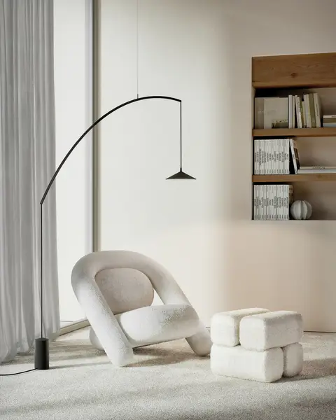 Een zwarte booglamp boven een witte bouclé fauteuil en poef, voor lange vitrage en een boekennis