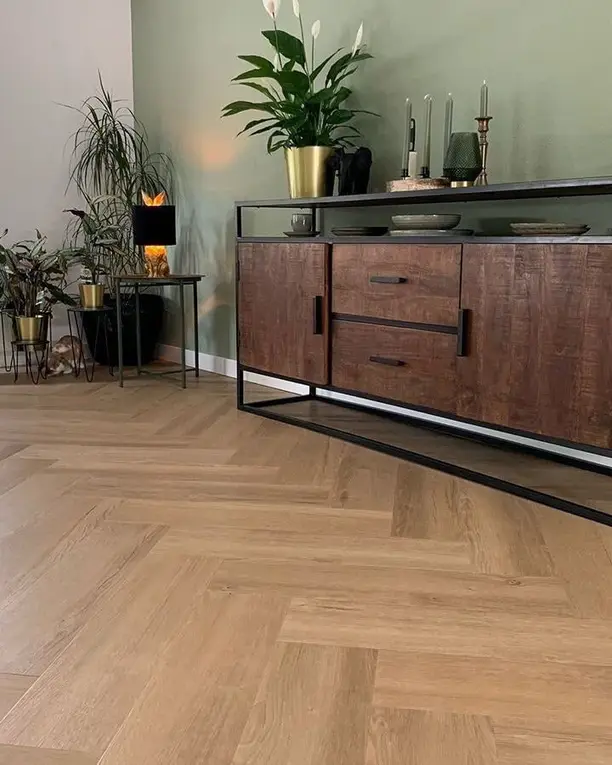 Brede visgraat in de kleur Boterkoek onder een houten dressoir met planten