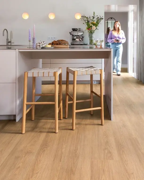 Lichte keuken met een kookeiland en rieten krukken op een eiken plankenvloer