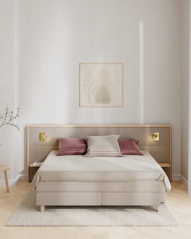 Een Inspiration-hoofdbord met houten omlijsting en twee messing leeslampjes boven een beige boxspring