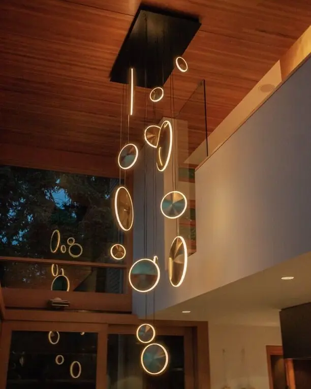 Ringen van licht hangen als een cluster onder een houten plafond in een hoge ruimte