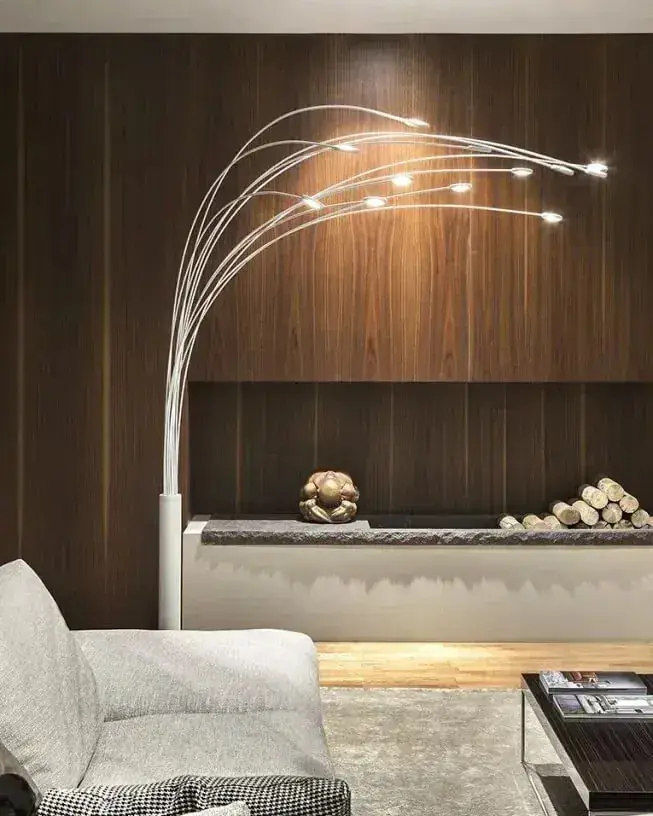Een booglamp met kleine lichtpunten boven een lichte bank voor een notenhouten wand