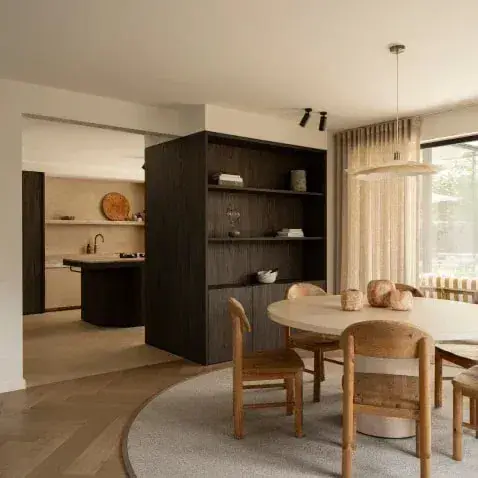 Ronde eettafel met houten stoelen op een rond karpet over een visgraatvloer