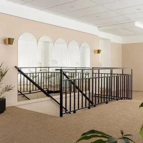 Overloop met een zwarte balustrade en boogspiegels op sisal