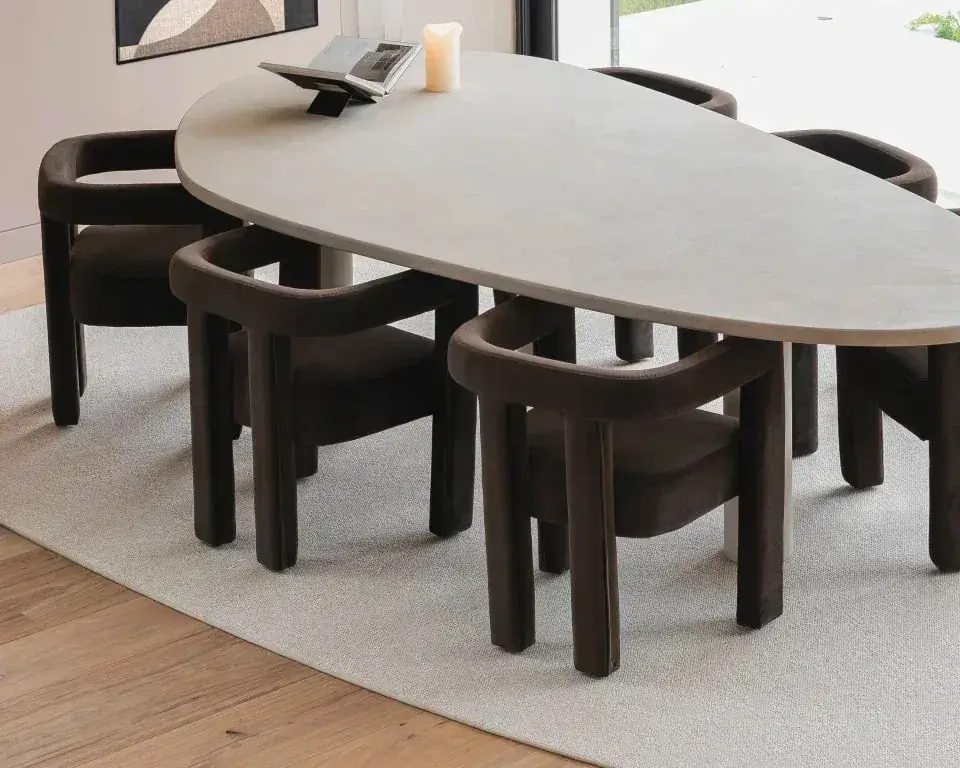 Organische eettafel met donkere stoelen op een licht wollen karpet over een eiken vloer