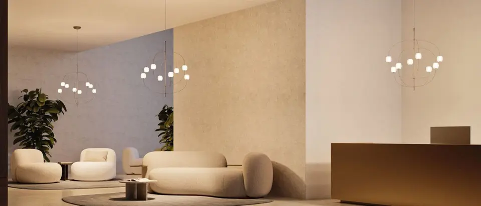 Een lichte lounge met ronde banken, planten en clusters van kleine glazen bollen aan dunne armen