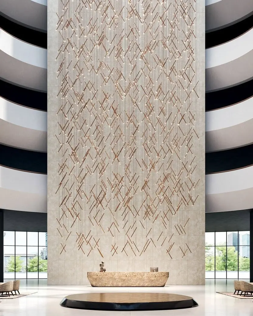 Een hoog atrium met een wand van schuine lichtstreepjes boven een ronde zithoek