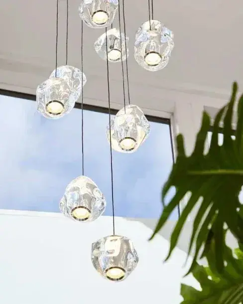 Heldere Ice Ball-bollen aan snoeren voor een raam, met een groene plant