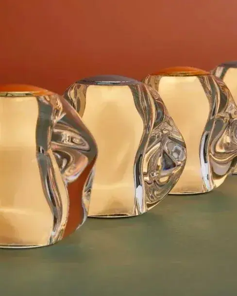 Een rij brandende lampjes van helder acryl voor een terracotta wand