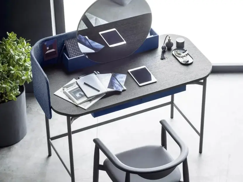 Bureau met een ronde spiegel en een houten stoel bij een groot raam