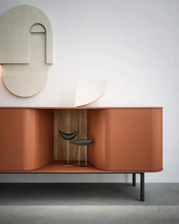 Gebogen terracotta dressoir met een open notenhouten vak tegen een witte wand