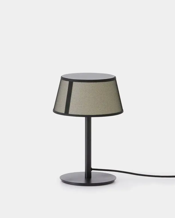 Een tafellamp met een kap van donker gaas in een metalen frame, op een lichte achtergrond