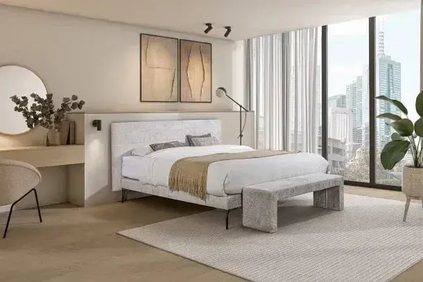 Een lichte boxspring met het hoofdbord Ripple en een gestoffeerd bankje, met uitzicht op de stad