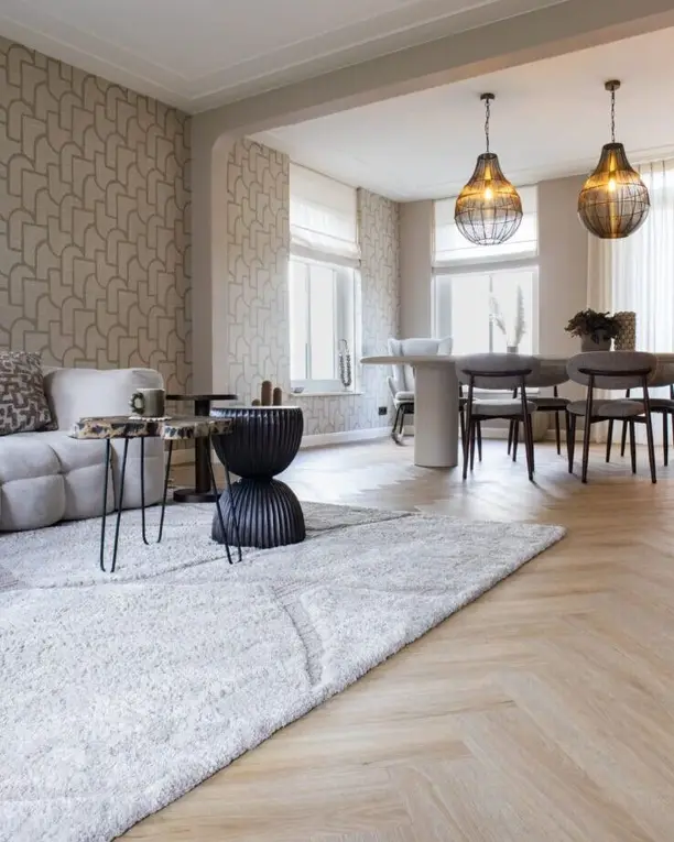 Woonkamer met een hoogpolig kleed op een lichte visgraat, doorkijk naar de eetkamer