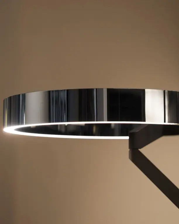 Een glanzende lichtring aan een dunne arm, met een smalle lichtlijn langs de onderrand