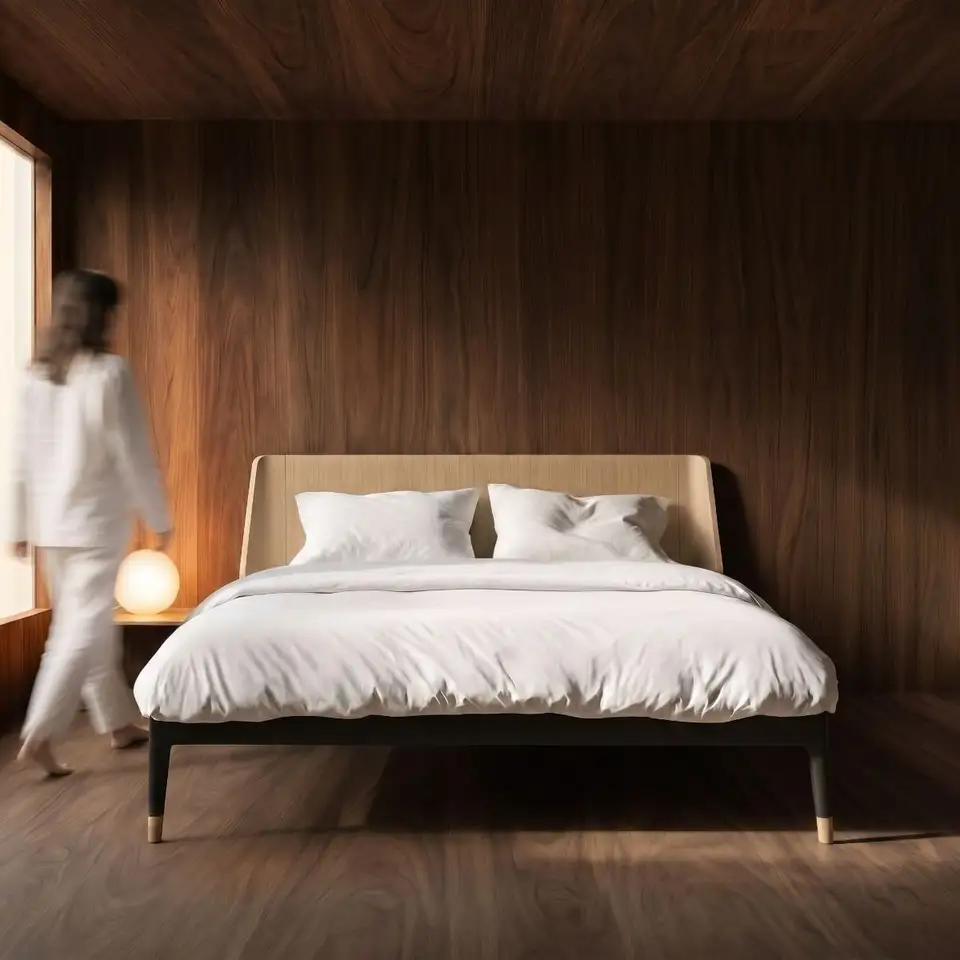 Auping Essential-bed met zwarte poten tegen een walnoten wand, een bollamp op het nachtkastje