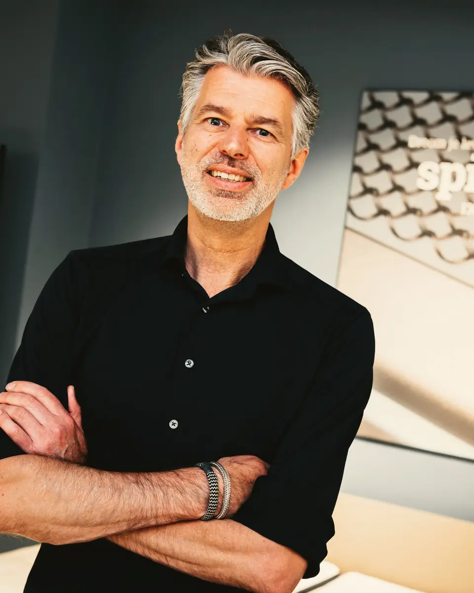 Ronald, eigenaar van Wielinga & Tabbers, met de armen over elkaar in de showroom