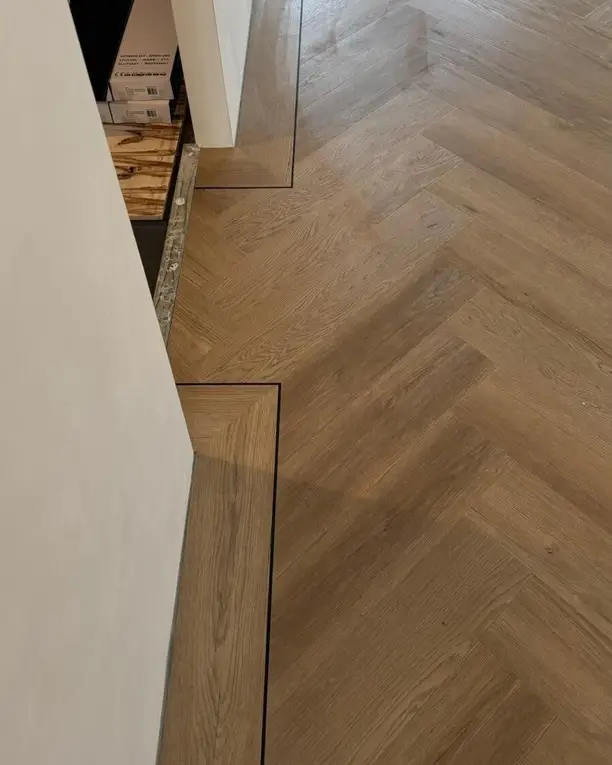 Visgraatvloer met een rechte bies langs de wand en een hoek